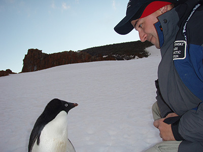 Mikolaj Golachowski and an Adelie penguin, Antarctica