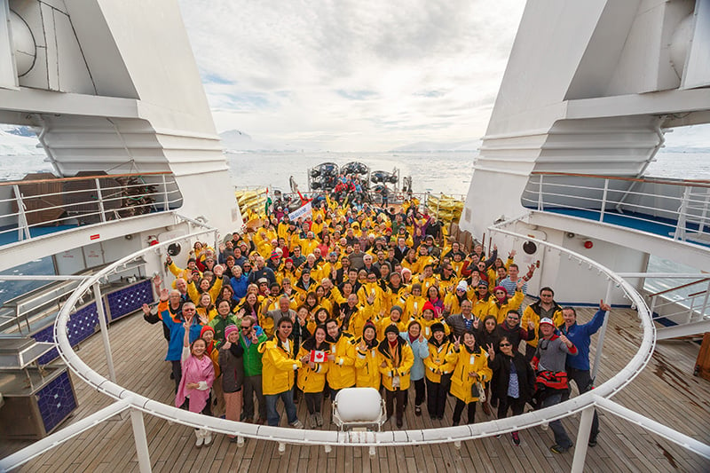 Passengers pose for photo on back deck of the ship