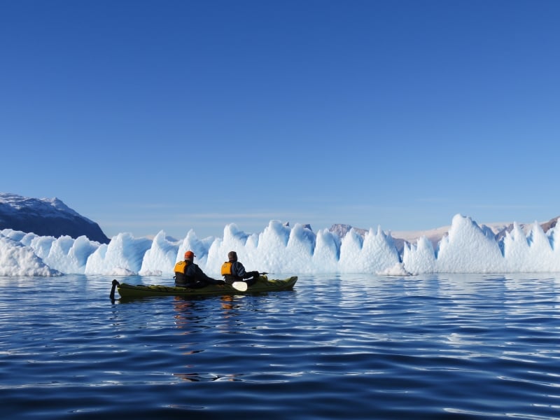 Spitsbergen passengers enjoying the optional kayaking program encounter a massive wall of ice in the their travels.